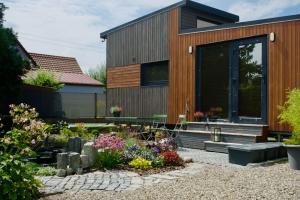 a house with a garden in front of it at Luxuriöses Tiny House in Burgheim