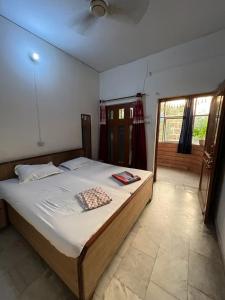 a bedroom with a large bed with white sheets at Madhuban Homestay, Natraj Chowk in Rishīkesh +10 photos