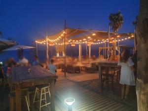 a group of people sitting at a bar on the beach at night at La BénéCIOLA, vue Mer, Box Fibre SFR, High Speed Internet in Cervione +44 photos