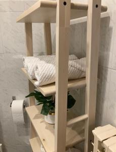 une étagère blanche avec des serviettes dessus dans une salle de bain dans l'établissement Apartamento El Olmo - casco histórico de Zaragoza, à Saragosse