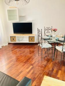 un salon avec une table et une télévision dans l'établissement Apartamento El Olmo - casco histórico de Zaragoza, à Saragosse