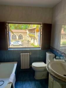 a bathroom with a toilet and a sink and a window at Hospedaje Angelica in Santillana del Mar +21 photos