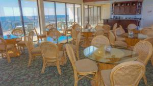 a dining room with tables and chairs and windows at Landmark Holiday Beach in Panama City Beach +30 photos