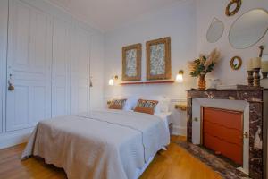 a bedroom with a white bed and a fireplace at La Maison D'Othe in Estissac
