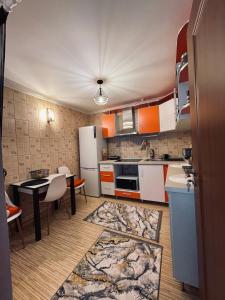 a kitchen with orange and white appliances and a table at RYD HOUSE Bucovina in Frumosu