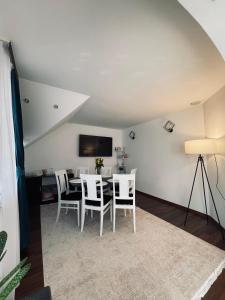 a dining room with a table and white chairs at RYD HOUSE Bucovina in Frumosu +7 photos