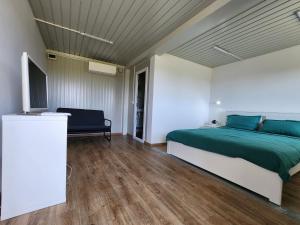 a bedroom with a bed and a flat screen tv at La Corbu in Corbu