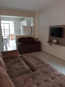 a living room with a couch and a television at Residencial Maravilha in Perequê