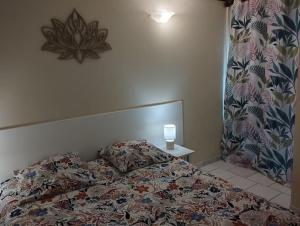a bedroom with a bed with a pillow and a lamp at Studio Zen Attitude à 10 minutes des belles plages in Le Marin