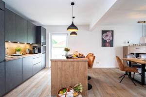 a kitchen with black cabinets and a wooden island at Ferienhaus Ostseeglück - Klausdorf in Klausdorf Mecklenburg Vorpommern
