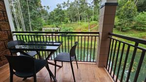 a patio with a table and chairs on a balcony at Casta Wild Resort in Batheri