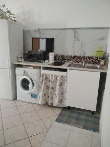 a kitchen with a washing machine and a sink at "HOUSE OF LELLA 2" appartamento 1 camera da letto - M1 METRO ROSSA in Milan