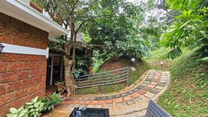 a brick walkway with a bench next to a house at Casta Wild Resort in Batheri