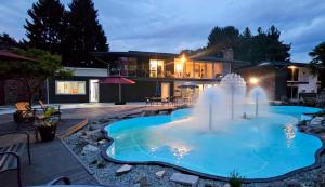 a swimming pool with a fountain in front of a house at Interurban Suites Hotel, a Dazzler Select by Wyndham in Tukwila