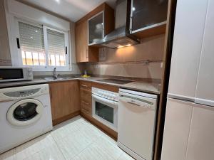 una cocina con lavadora y lavadora en ACV - Costa Azahar II-2ª linea planta 6 norte 2, en Oropesa del Mar