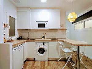 a kitchen with white cabinets and a washing machine at LM27 Beach "Little Blondies" in Las Palmas de Gran Canaria