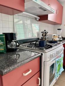 a kitchen with pink cabinets and a stove top oven at CASA MERiTHIA, Céntrica Casa Ejecutiva in Momoxpan