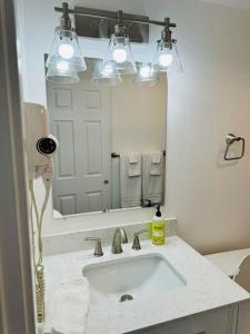 a bathroom with a sink and a large mirror at Executive upper floor apartment 10 in Fairbanks