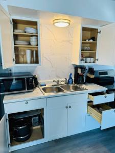 a kitchen with a sink and a microwave at Executive upper floor apartment 10 in Fairbanks +10 photos