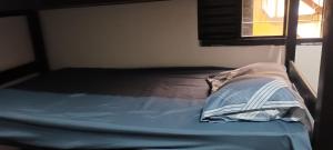 uma cama com um lençol azul e uma almofada em Lar Do Viajante Diárias 22 Reais em São Paulo