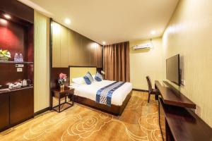 a hotel room with a bed and a desk and a television at Bosheng International Hotel Guangzhou Baiyun International Airport Huadu Plaza Branch - Free Deliver Service to Guangzhou Baiyun International Airport & Free Deliver Service to Canton Fair Complex During Canton Fair Period in Huadu +24 photos
