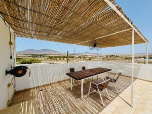 a patio with a table and chairs under a roof at Apartamento as Lombas in Cardón