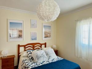 a bedroom with a bed and a chandelier at Apartamento as Lombas in Cardón