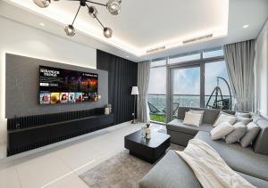 ein Wohnzimmer mit Couch und Fernseher in der Unterkunft 5 Star High Rise Luxury Apartment, Infinity Pool With Stunning Burj View - Brand New Apartment in Dubai