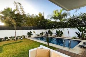 a backyard with a swimming pool and a garden at Poolside Paradise Villa in Dar Ben Abdallah Ben Dehbi +8 photos