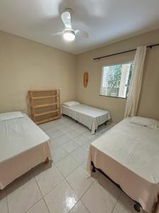 a bedroom with two beds and a window at Surf Stop Hostel Serra Grande in Uruçuca
