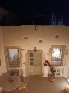 a room with two tables and a door and two windows at Latmos 1860 in Skala