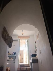 a hallway with an archway leading to a room at Latmos 1860 in Skala