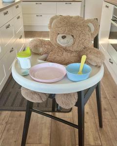 a teddy bear sitting on a table with plates and bowls at Villa Talmo, Kimito island in Kemionsaari