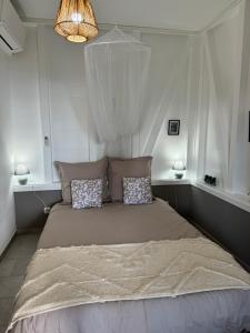 una camera da letto con un letto grande con due cuscini di PAVILLON TI GEMME LE DIAMANT a Le Diamant