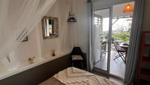 una camera con letto e porta scorrevole in vetro di PAVILLON TI GEMME LE DIAMANT a Le Diamant Altre 13 foto