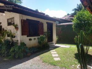 a house with a window and a yard with cactus at Loft situado a 700 metros da praia de Boiçucanga in Boicucanga +7 photos