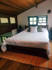 a bedroom with a large bed in a room with windows at Loft situado a 700 metros da praia de Boiçucanga in Boicucanga