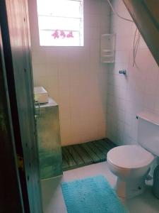 a bathroom with a toilet and a window at Loft situado a 700 metros da praia de Boiçucanga in Boicucanga