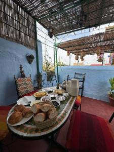 a table with bread and baskets of food on it at Dar Enouiina in Fez +85 photos