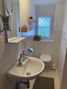 a white bathroom with a sink and a toilet at Eistänzer Nest in Oberstdorf