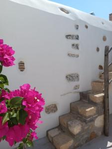 a staircase with pink flowers next to a wall at Latmos 1860 in Skala