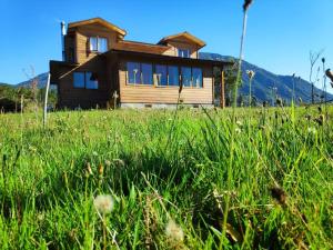 a house in the middle of a field of grass at Family home, panoramic views of lake & countryside in Puerto Rico
