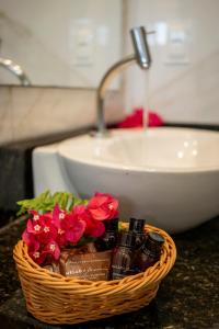 a basket with flowers on a counter with a sink at Vila Gallina Pousada in Jericoacoara +34 photos