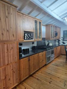 a kitchen with wooden cabinets and black counter tops at Rainsough Cottage Guest House - Sleeps upto 8 with ensuite - Free Parking & WiFi in Manchester