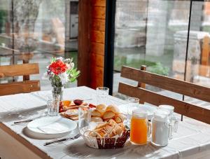 a table with a plate of bread and orange juice at Vila Alpini in Razëm