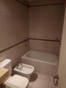 a bathroom with a toilet and a bath tub at Edificio San Lorenzo in Corrientes +4 photos