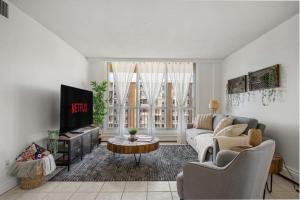 a living room with a couch and a tv at Downtown Near Rogers Place with Covered Parking, Sleeps 6, Pool Table, Sauna, Gym, Two Bedrooms & More in Edmonton