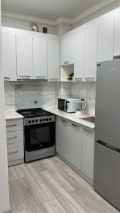 a kitchen with white cabinets and a stove and refrigerator at Апартамент в центре города Классик in Bishkek +5 photos