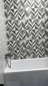 a bathroom with a black and white checkered wall at Апартамент в центре города Классик in Bishkek