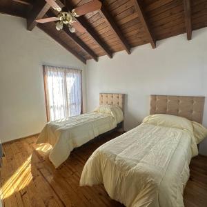 ein Schlafzimmer mit zwei Betten und einem Deckenventilator in der Unterkunft Encantos del Valle - Santa Rosa de Calamuchita in Santa Rosa de Calamuchita + 28 Fotos
